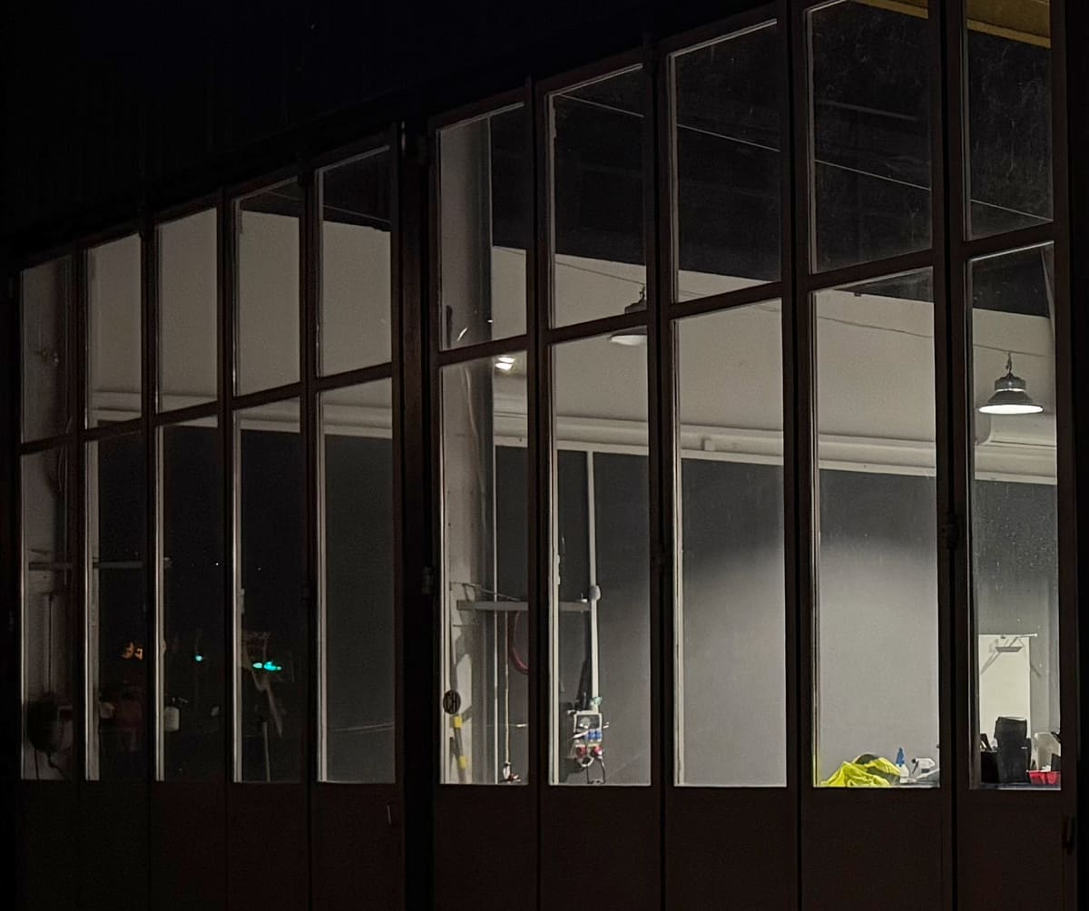 Blick durch die beleuchtete Glasfront in den Showroom, am Abend
